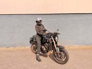 Geslaagde motorrijder met helm op de Honda CB650R