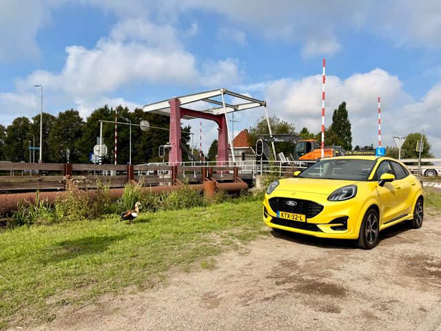De gele Ford Puma van De Rijkoning bij een ophaalbrug