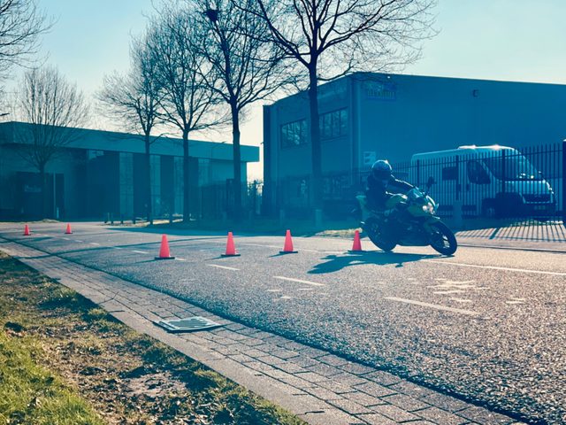 Motorleerling op het oefenterrein tussen de pionnen